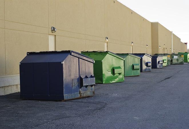 a row of industrial dumpsters at a construction site in Alton